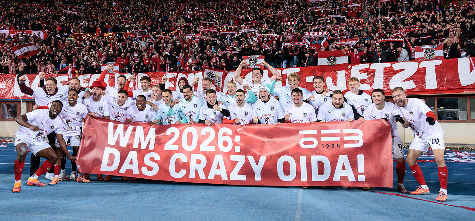 Großes Gruppenfoto des ÖFB Teams mit einem roten Banner mit der Aufschrift WM 2026: Das Crazy Oida!