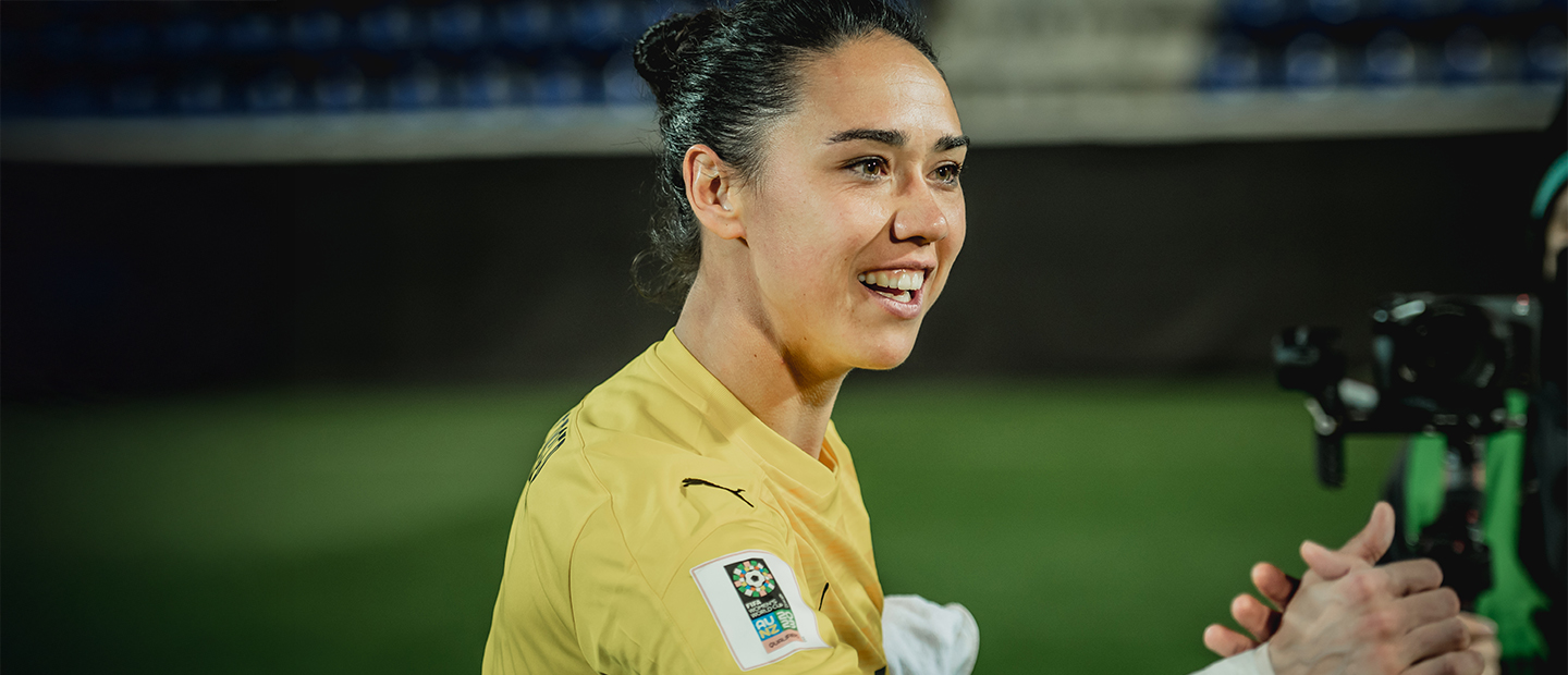 ÖFB-Torfrau Manuela Zinsberger lächelnd im gelben Nationalteam-Trikot.