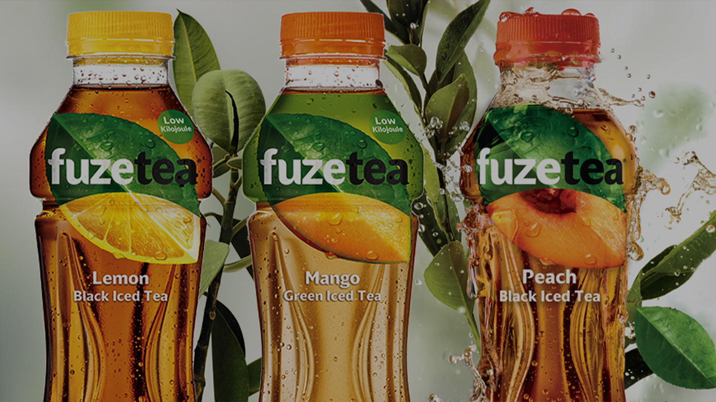 Three Fuze Tea bottles in front of a green and white background 