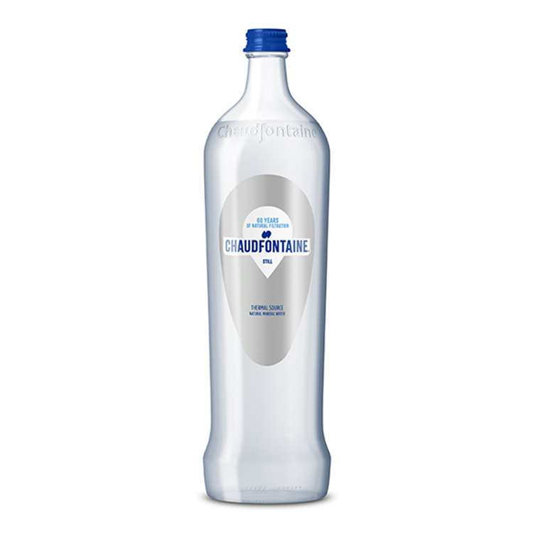 Bouteille en verre transparente d’eau minérale naturelle plate Chaudfontaine, avec bouchon bleu et étiquette indiquant « 60 years of natural filtration – Still ».