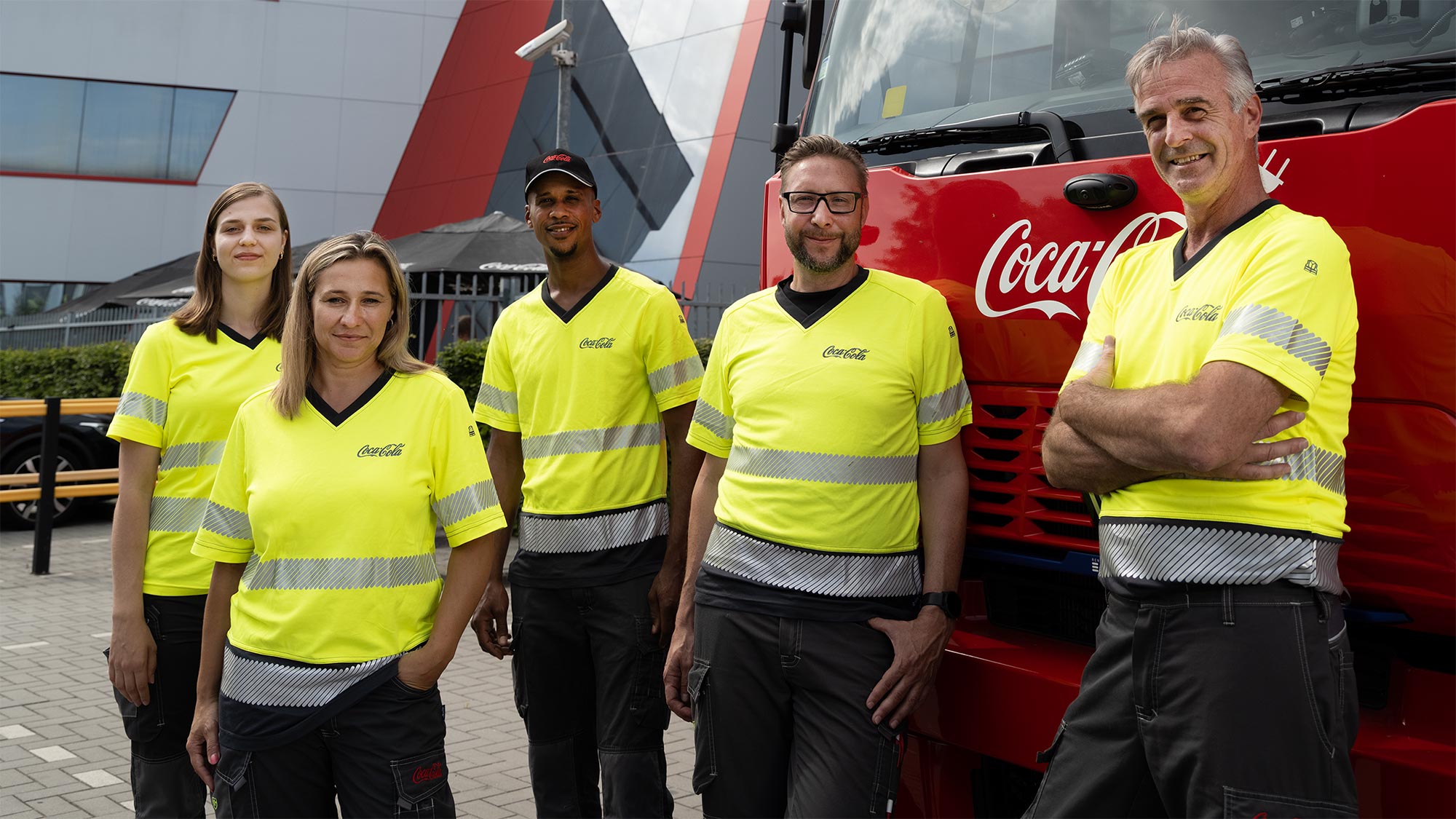Werknemers Coca-Cola poseren naast elkaar