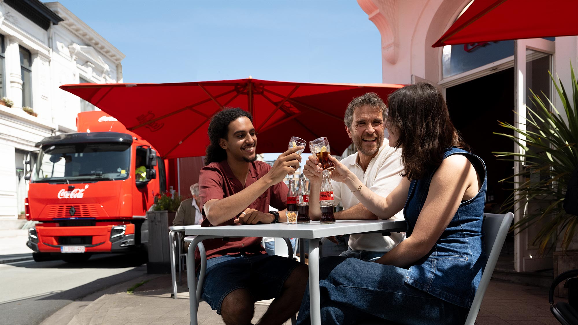 3 Belgische inwoners drinken Coca-Cola op een terras