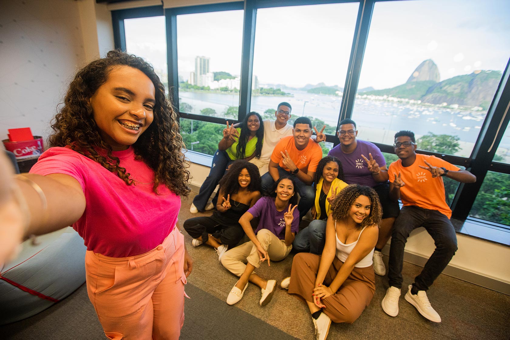 Grupo de jovens posando juntos sorrindo alegremente.