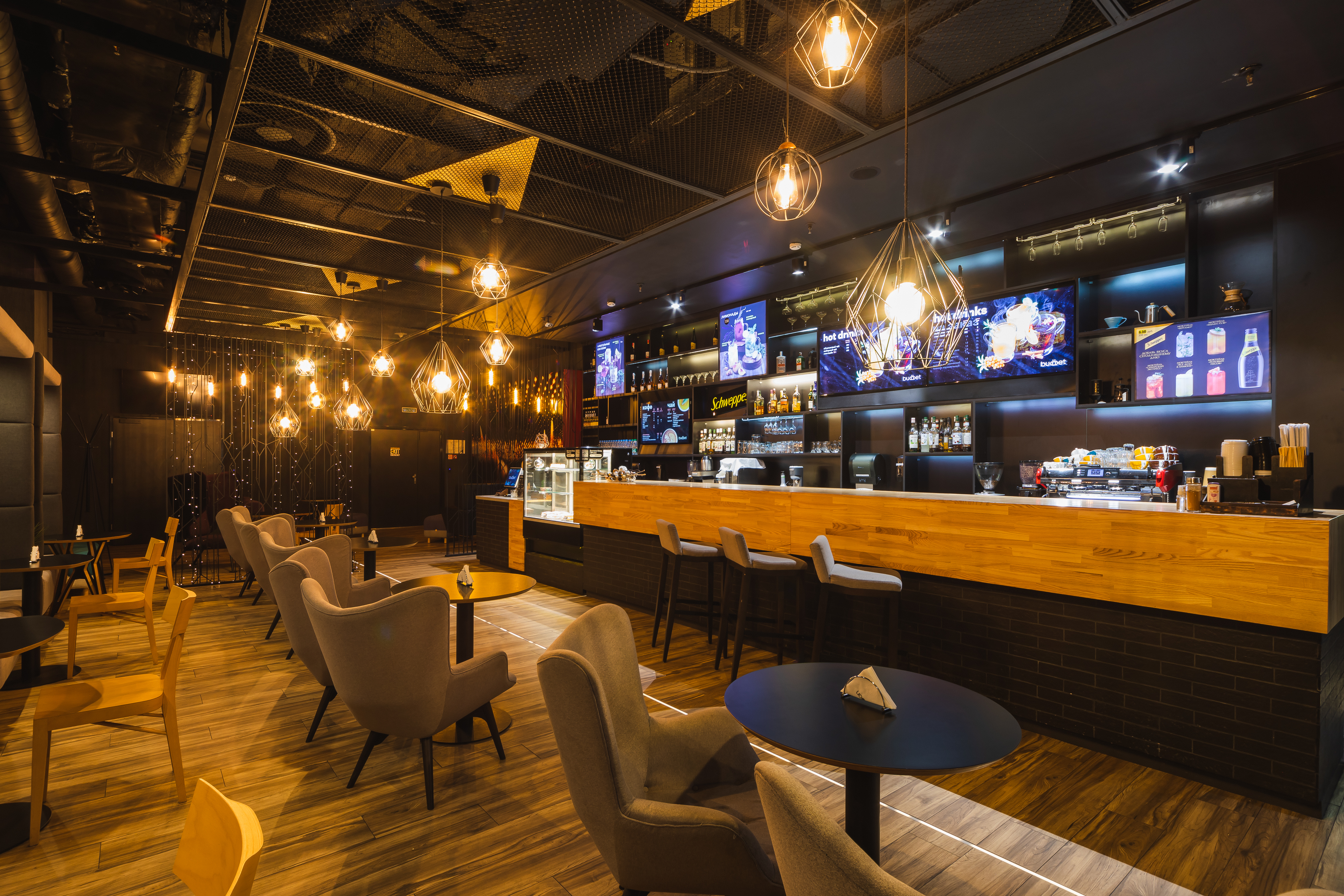 Цёпла асветлены бар з драўляным прылаўкам і зонай для адпачынку