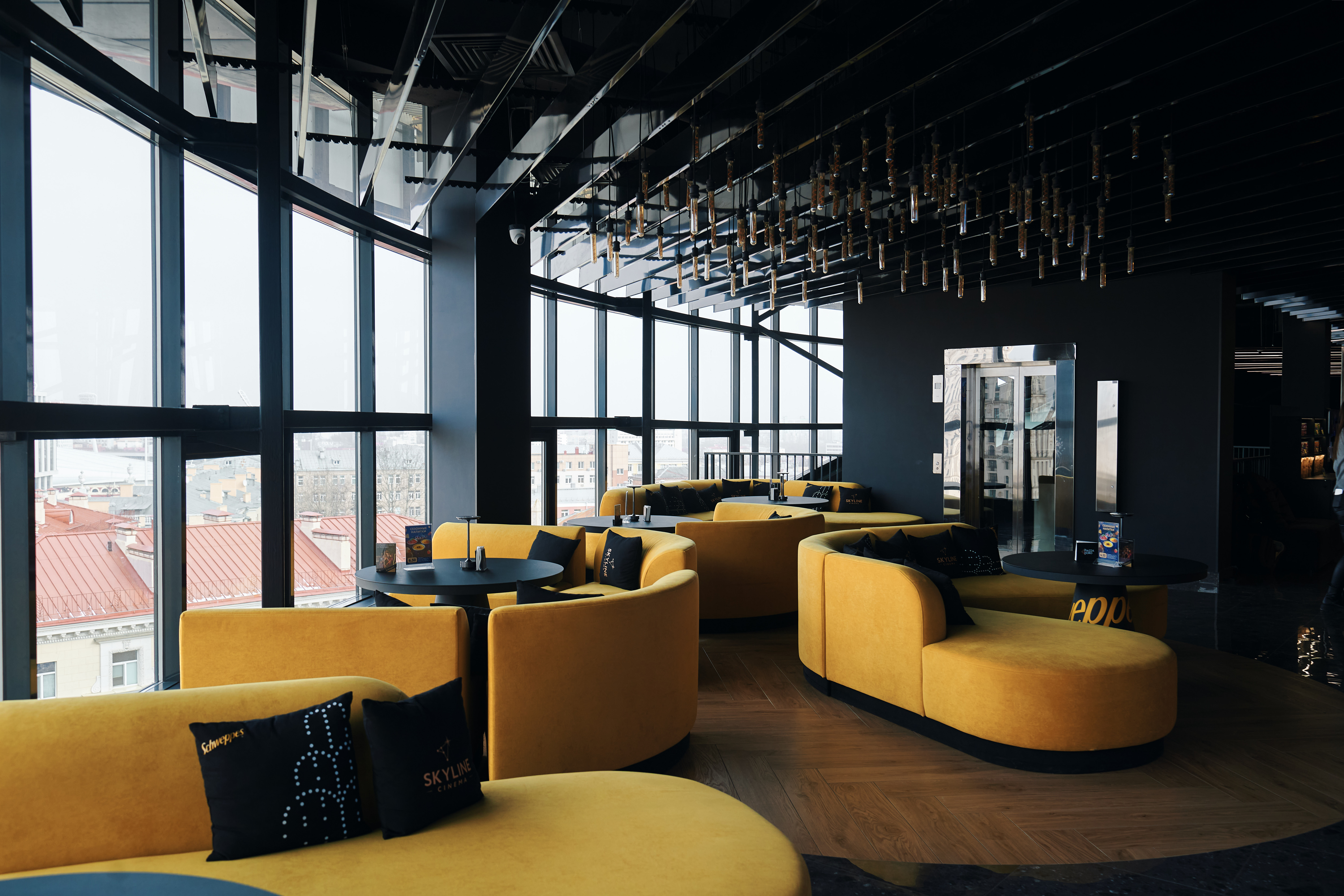 Стыльная лаунж-зона з жоўтымі канапамі і панарамнымі вокнамі