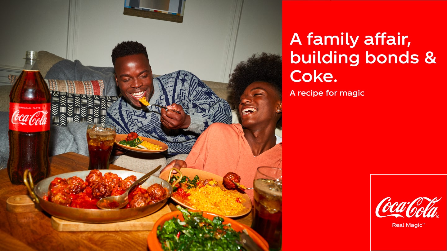 Two young people laugh and enjoy a meal with an Original Flavor Coca-Cola. On the right side, the following text can be read on a red background: A family affair, building bonds & Coke. A recipe for Magic. Below right is the Coca-Cola logo.