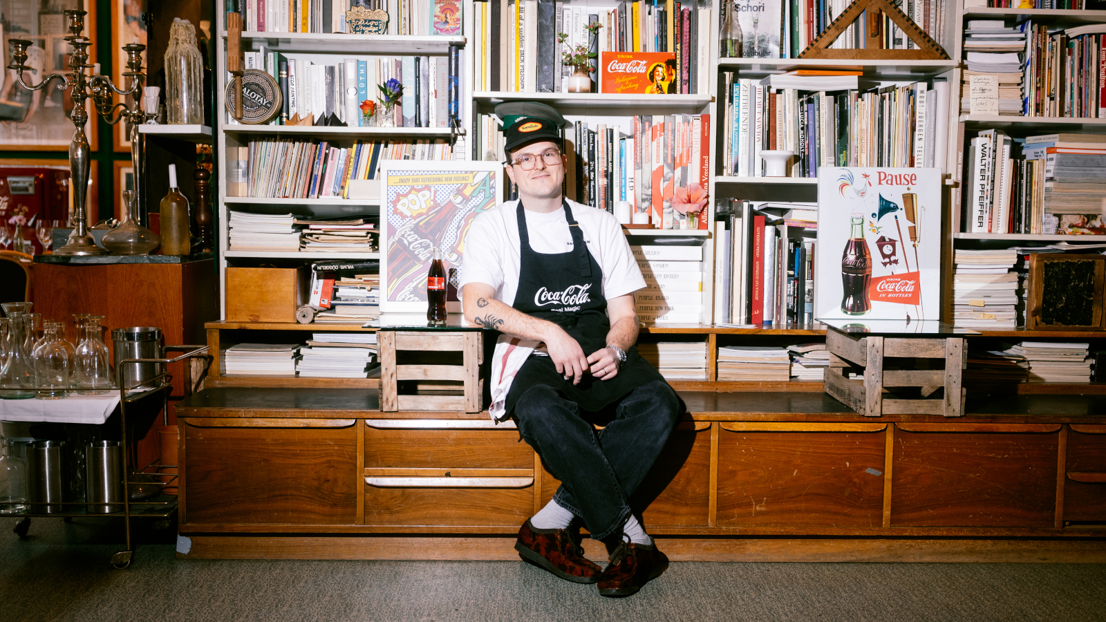 Noah Bachofen sits in front of a bookshelf