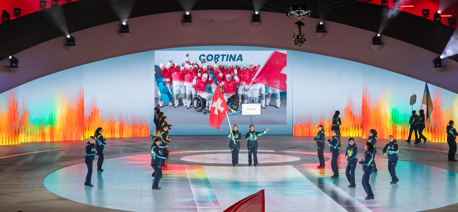 Flavio mit Fahnenträgerin an der Eröffnungsfeier der Paralympics Winterspiele in Verona auf der Bühne