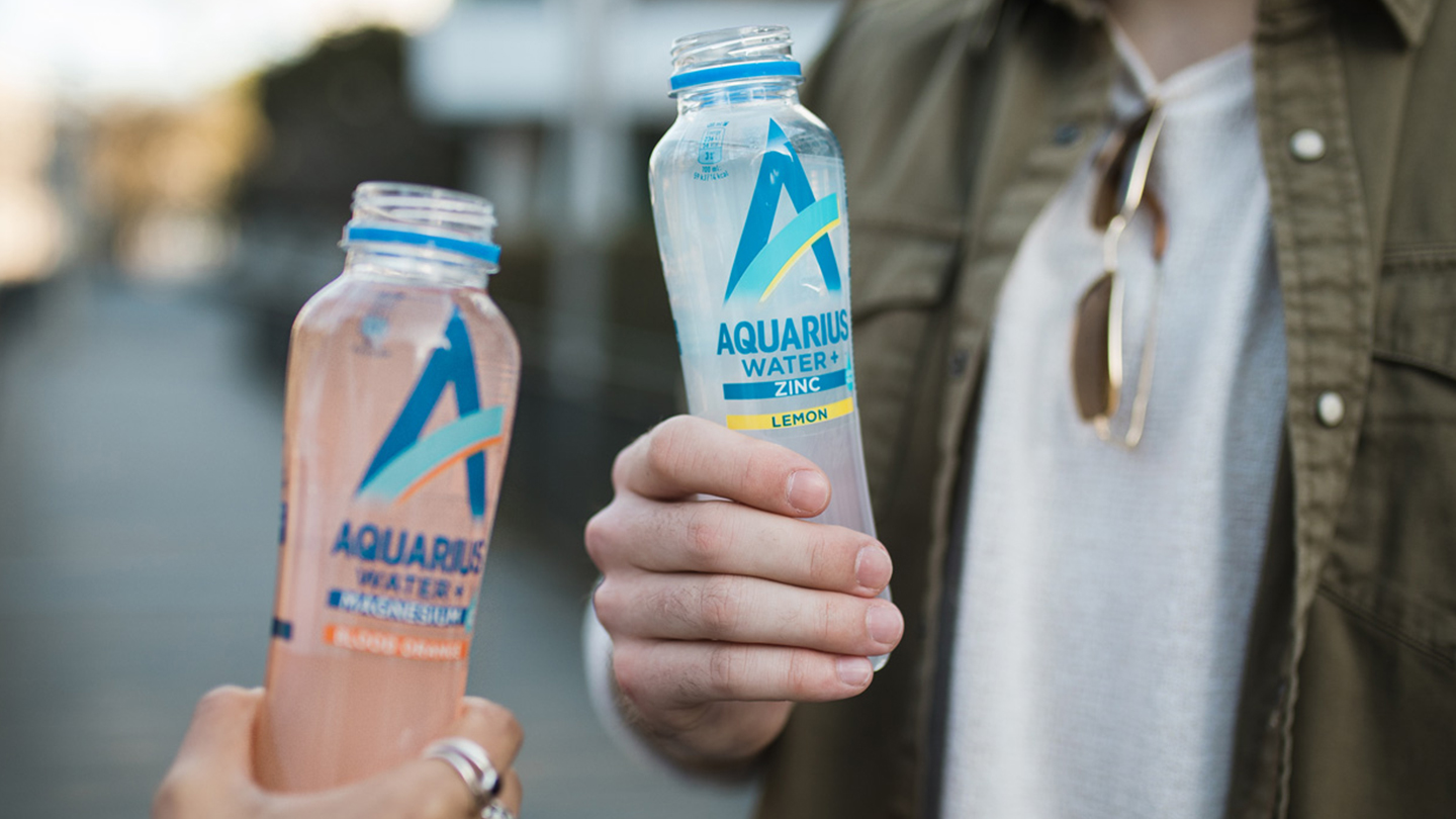 Deux personnes tenant des bouteilles d’Aquarius