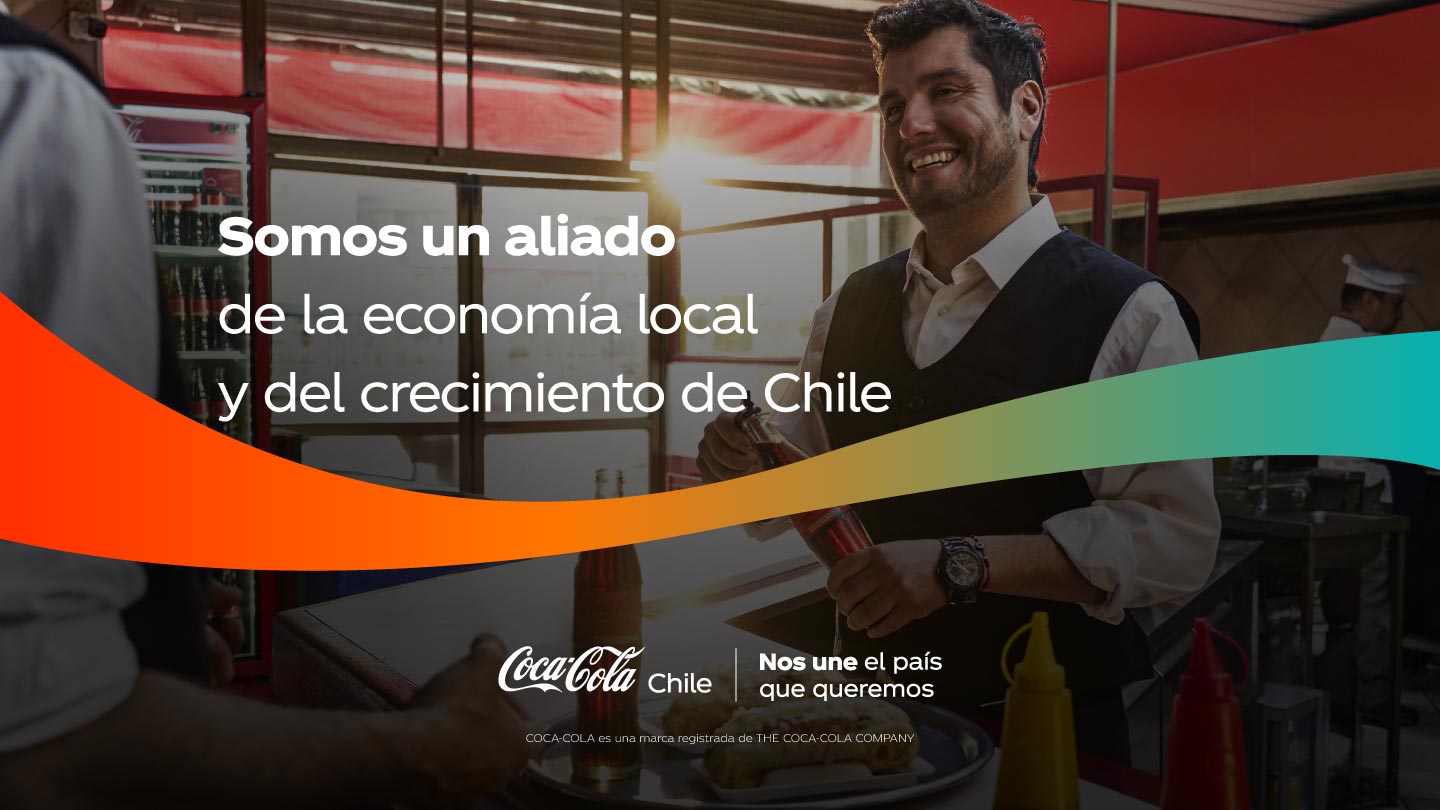 Hombre sonriente atendiendo en un local de comida, con botellas de Coca-Cola de fondo.