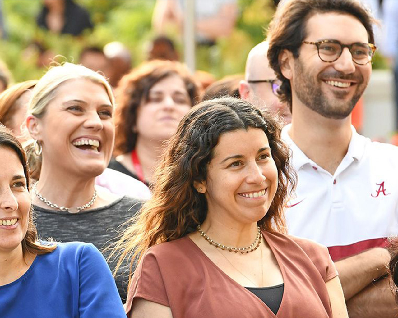 Skupina šťastných studentů se usmívá a pozoruje něco venku.