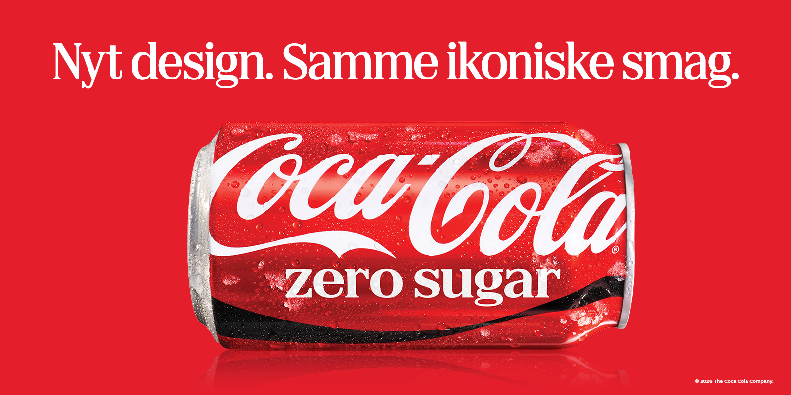 En Coca-Cola Zero Sugar-dåse ligger vandret på en rød baggrund med kondensdråber på overfladen. Øverst står teksten: “Nyt design. Samme ikoniske smag.”