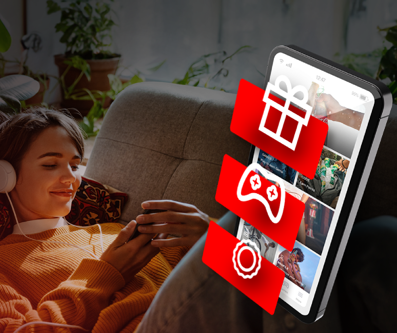 Kvinde kigger på telefon og smiler med billede af Coca-Cola-appen ovenpå