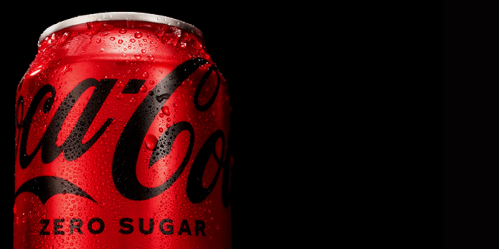 En rød dåse Coca‑Cola Zero Sugar med kondensdråber på overfladen mod en sort baggrund.