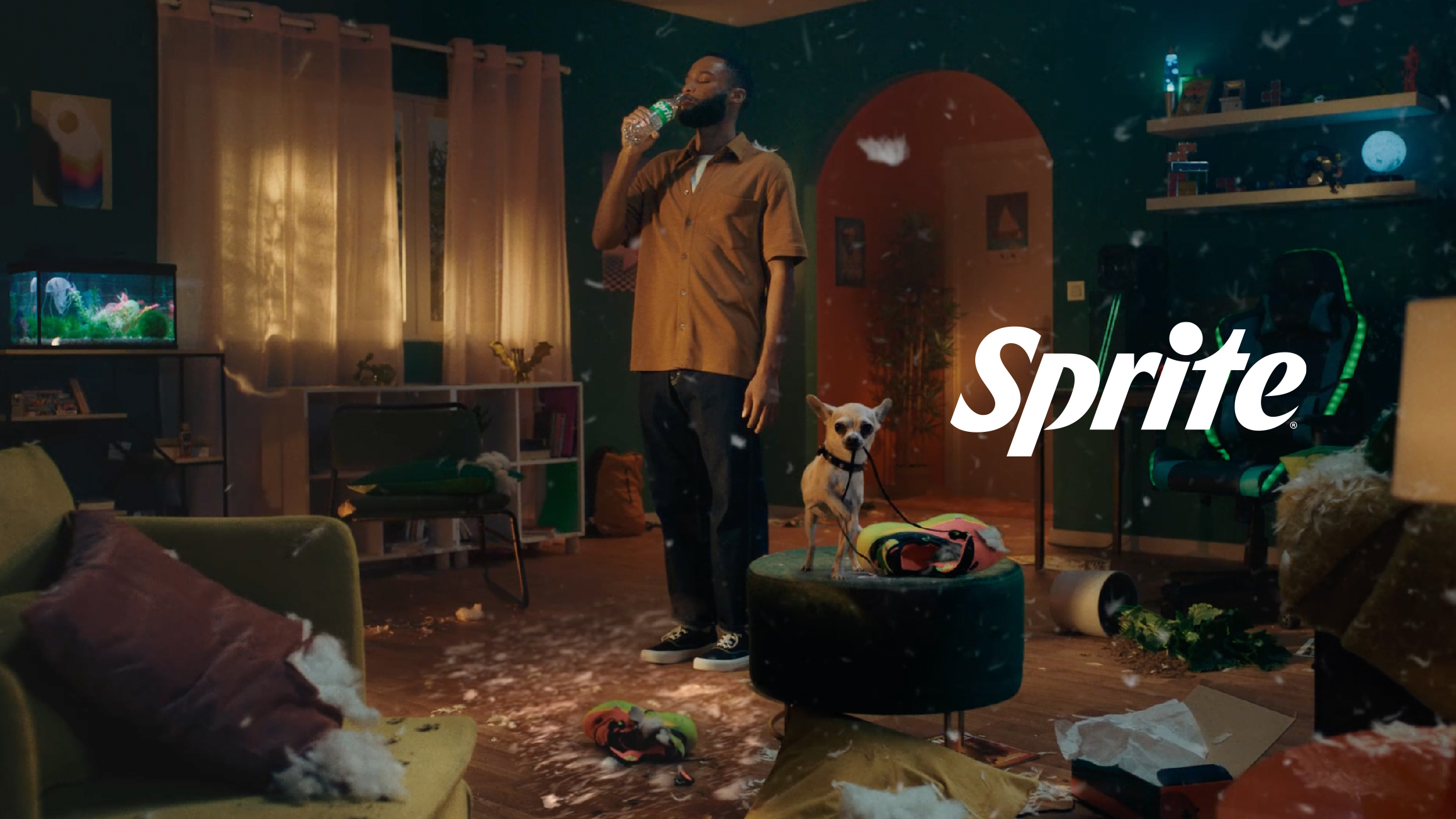 Man drinks Sprite in messy living room with dog; Sprite logo and slogan displayed.
