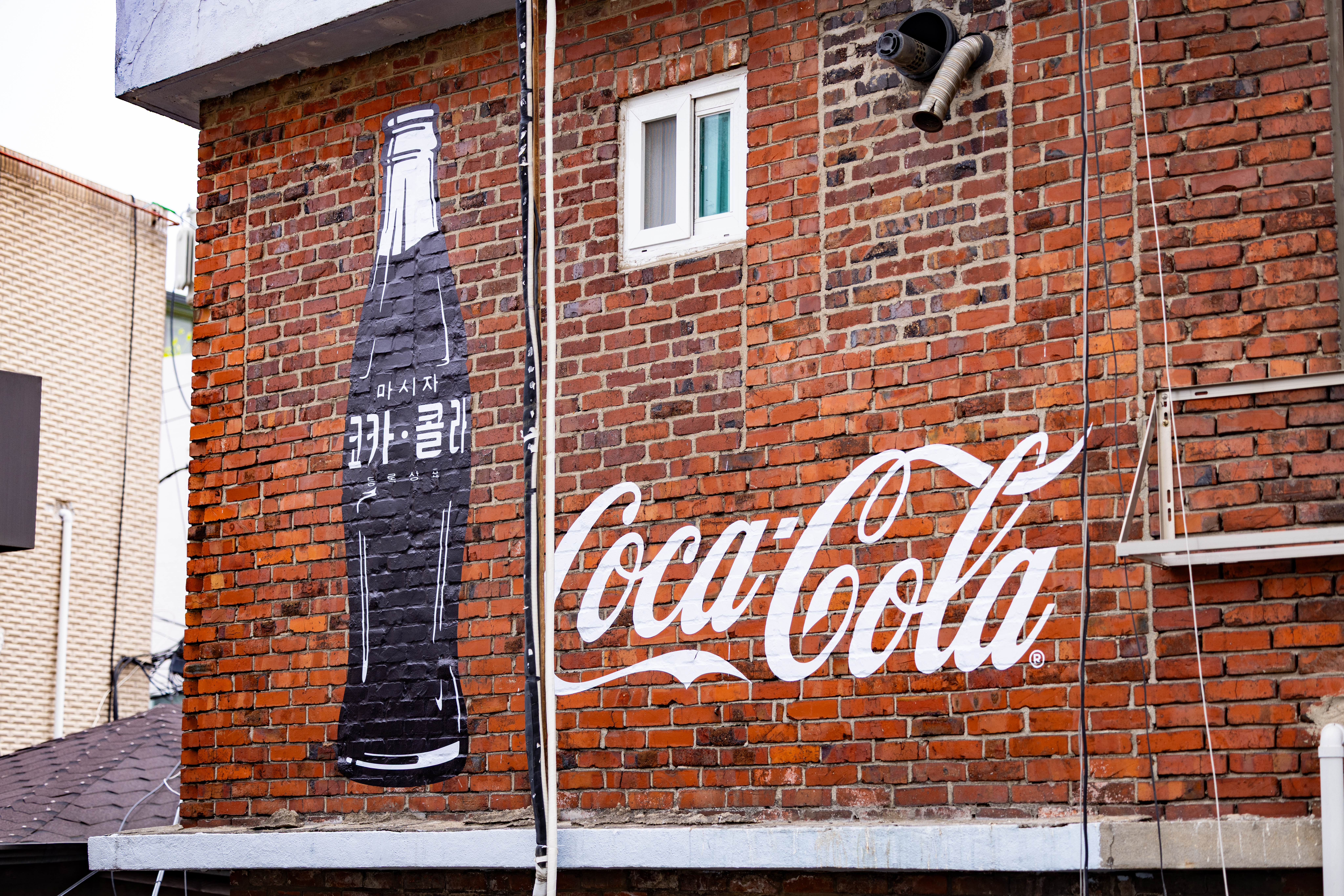 신흥 시장 내 건물 벽에 그려진 코카-콜라 병과 코카-콜라 로고