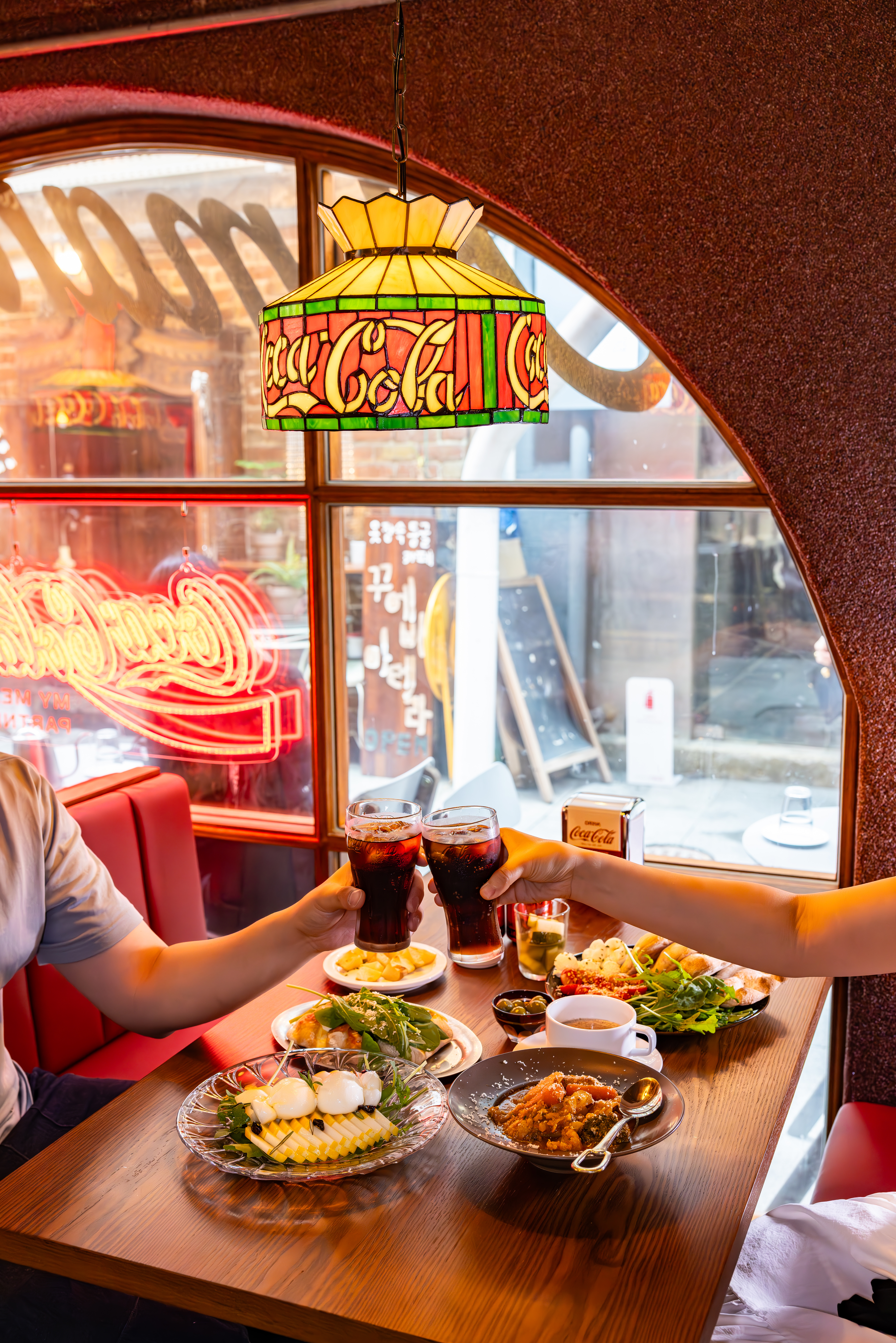 코카-콜라 X 신흥시장 프로젝트 참여 식당, 비스트로 조조, 오리올 남산유원지점 내부 코카-콜라 인테리어와 음식을 즐기는 이미지