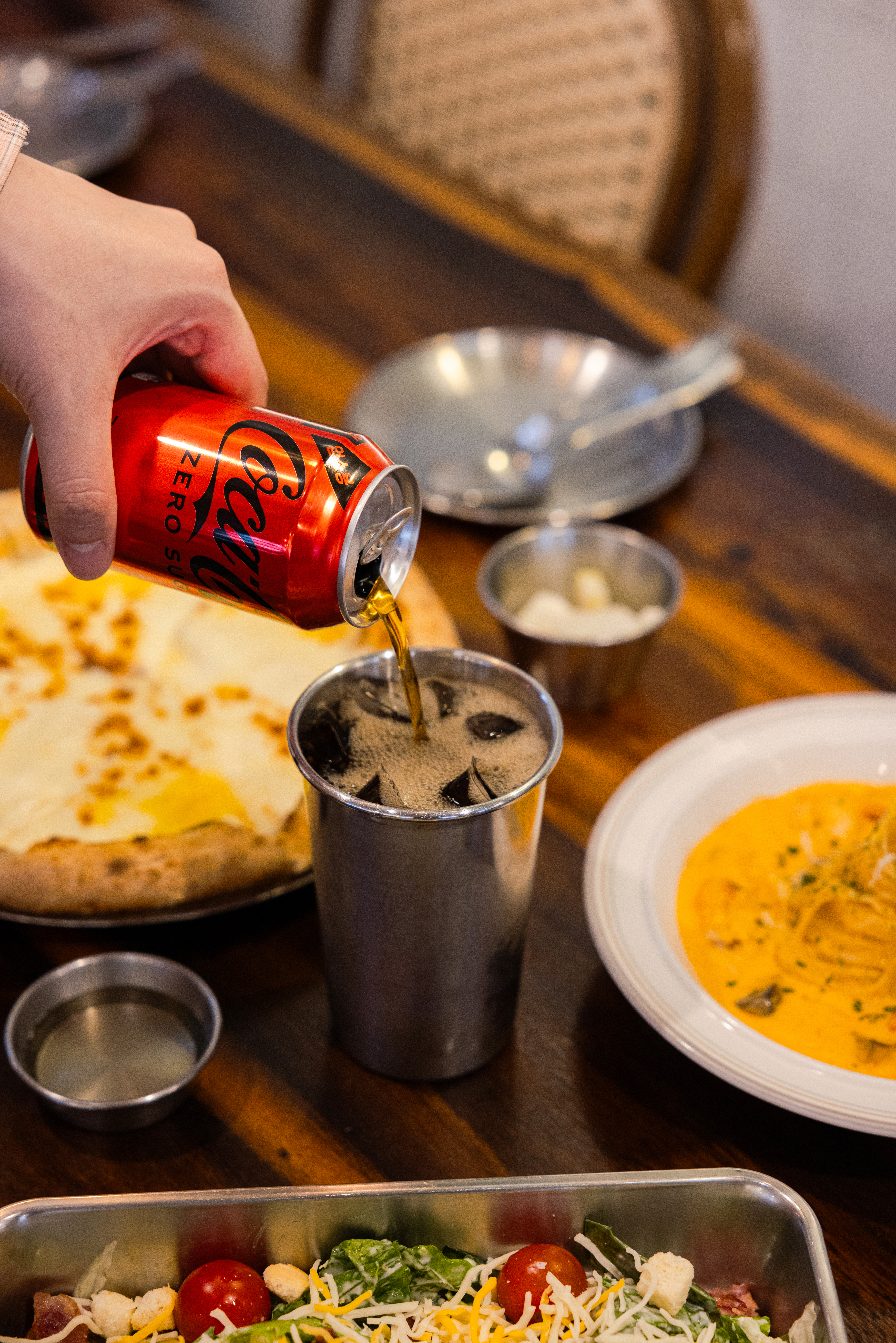 명동피자의 대표메뉴들과 코카-콜라 제로를 컵에 따르는 사진