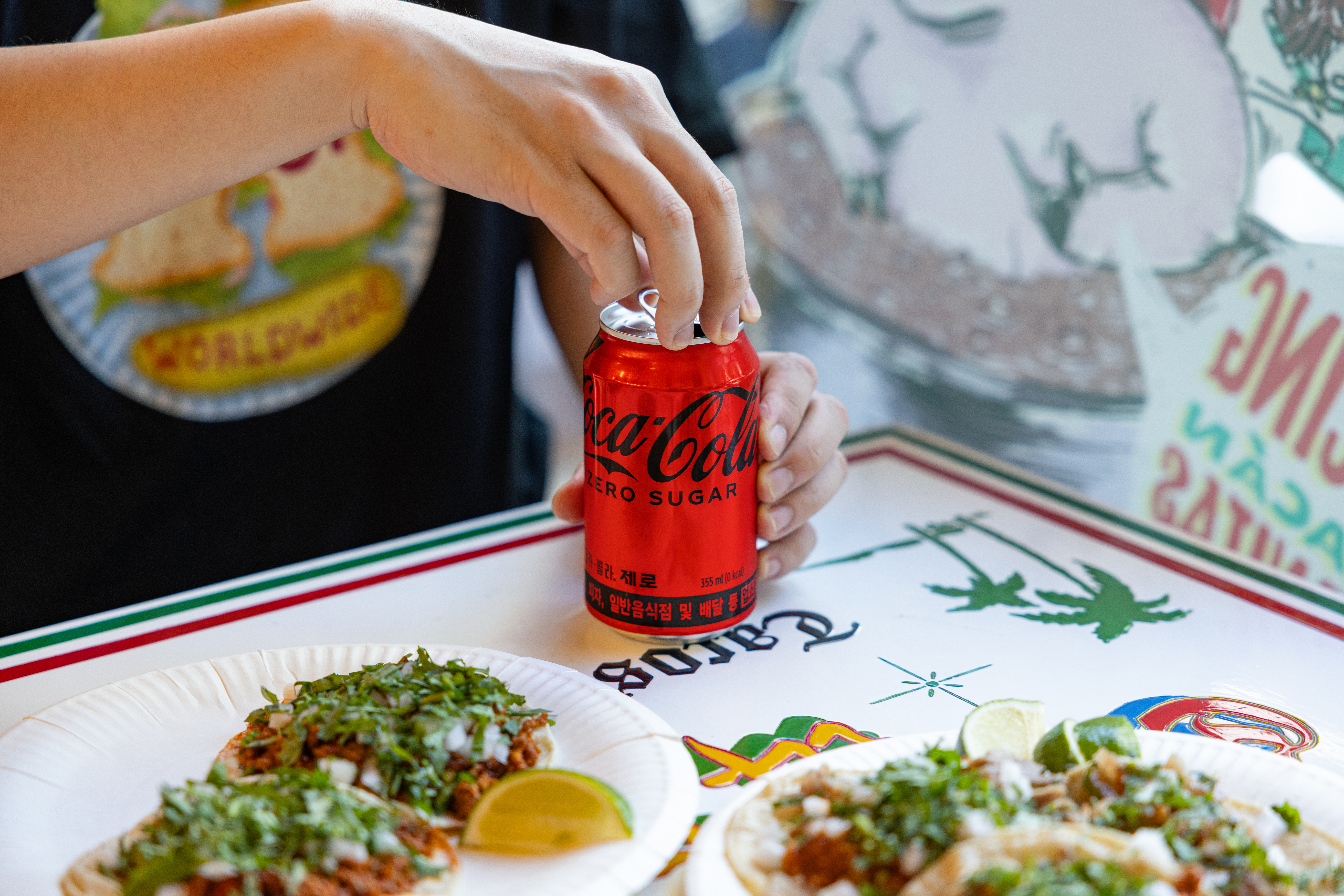 ‘비야게레로’의 대표 메뉴들과 코카-콜라 제로 캔을 따고 있는 사진