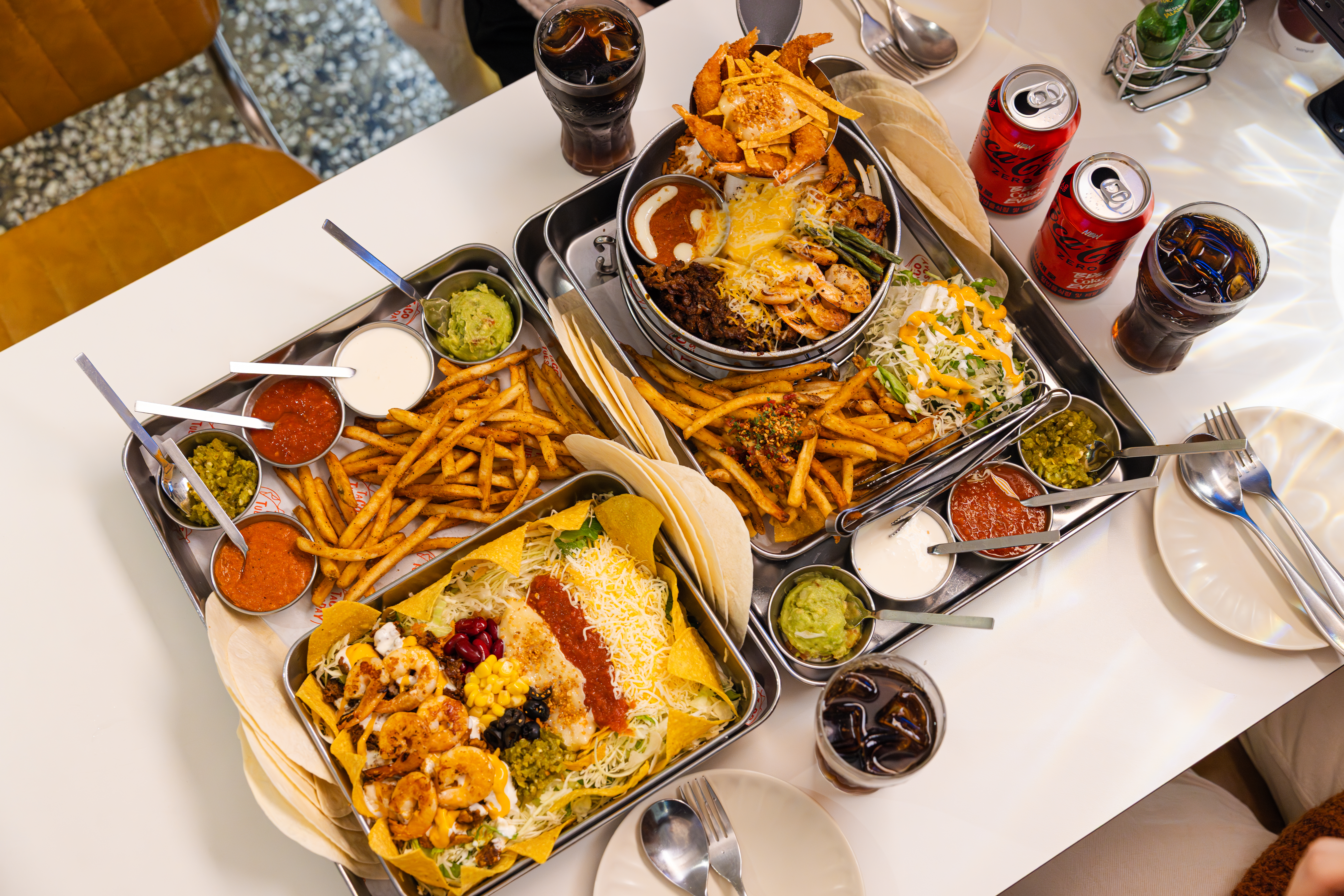 '타코튜즈데이'의 대표메뉴, 서울숲 갈릭 플래터와 3단 갈릭 소울 파히타를 코카-콜라 제로와 함께 즐기고 있다.