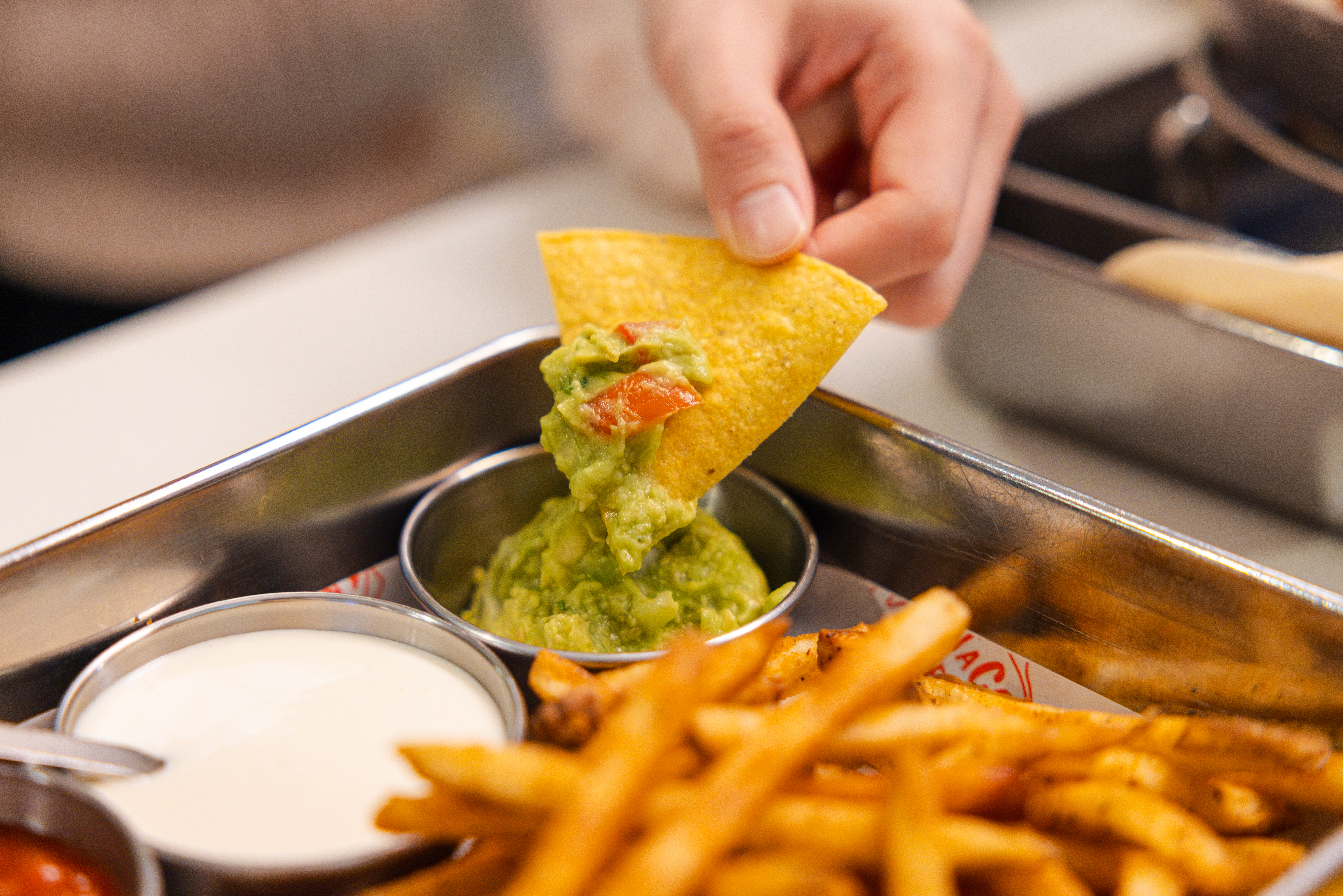 '타코튜즈데이'의 대표메뉴, 서울숲 갈릭 플래터에 포함된 나쵸 칩을 과카몰리에 찍어먹고 있다.