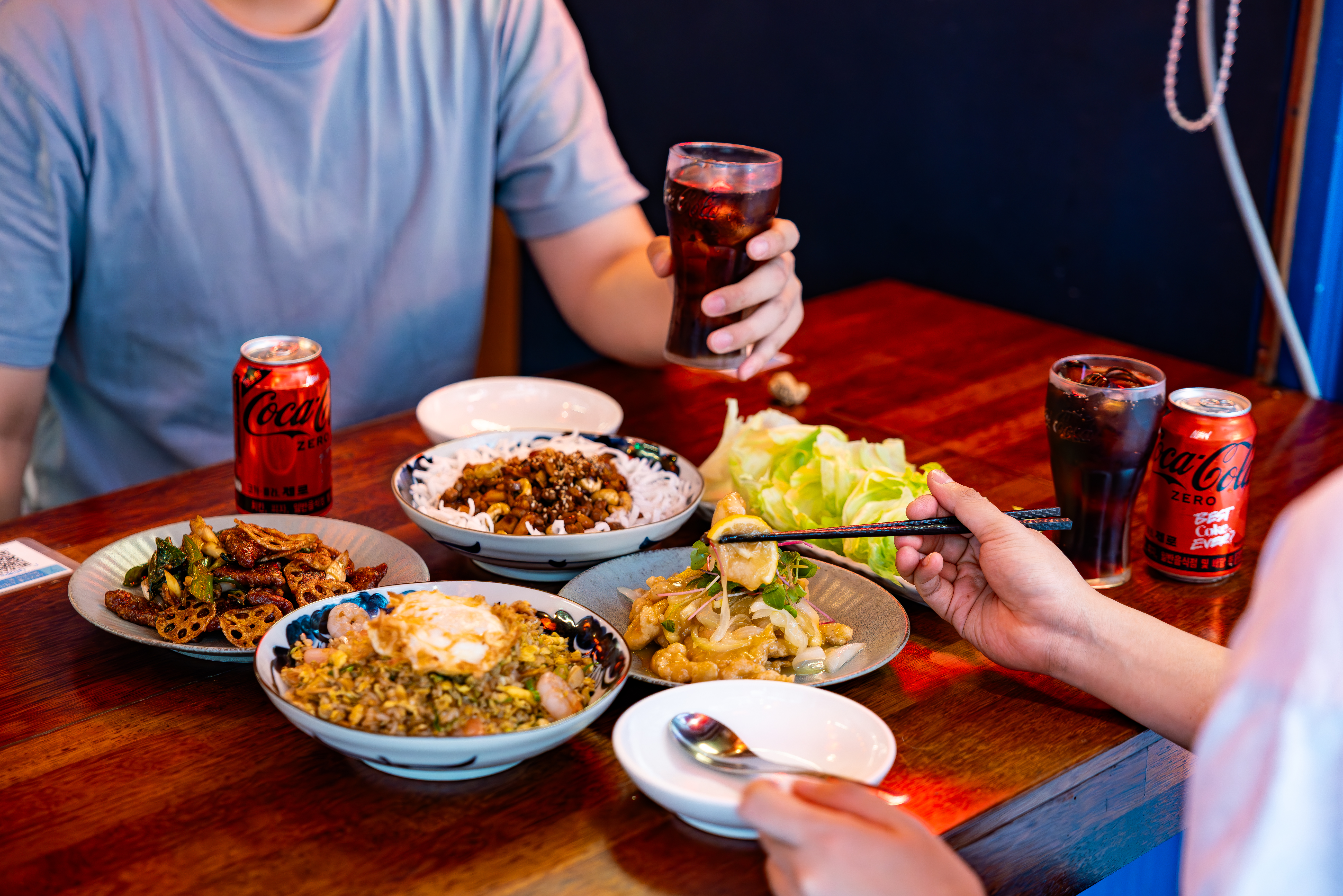 H5NG의 대표 메뉴들과 새로워진 코카-콜라 제로를 즐기는 이미지