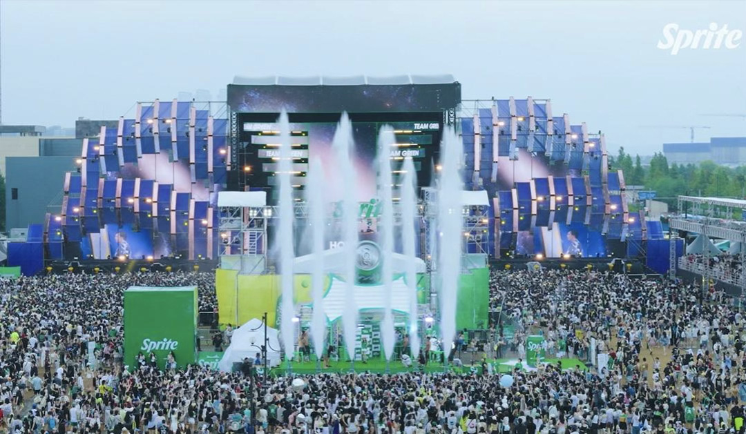 사람들로 가득 찬 스프라이트 워터밤 페스티벌 전경으로, 대형 무대에서 물이 뿜어져 나오는 시원한 현장 모습