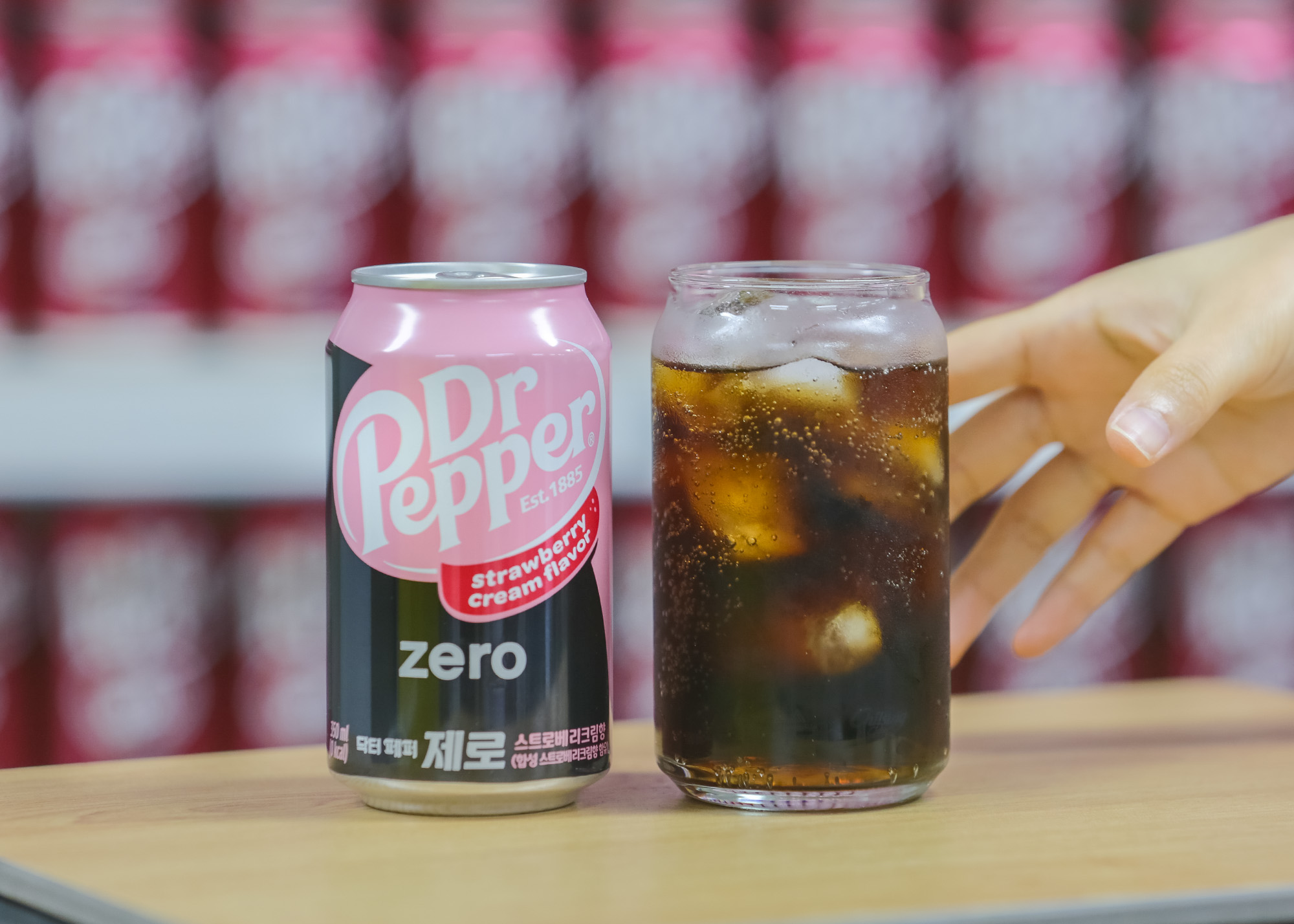 얼음컵에 든 닥터페퍼 제로 스트로베리크림향과 그 옆에 놓여진 음료 캔