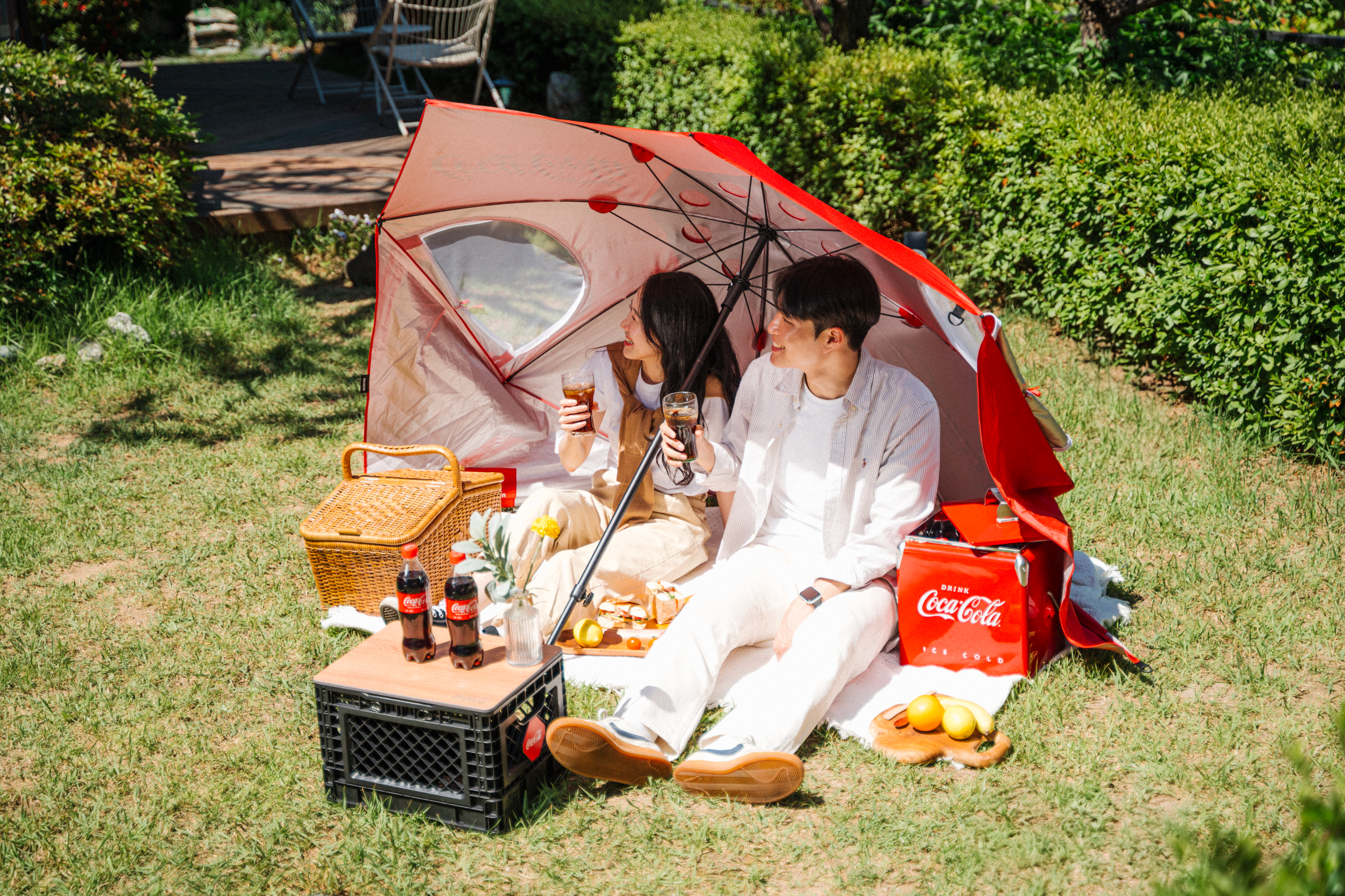 원더플 우산 텐트 아래 두 사람이 코카-콜라와 함께 피크닉을 즐기고 있는 모습