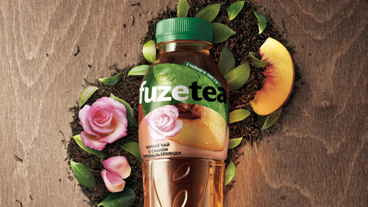 Imagine: natură moartă cu o sticlă de Fuzetea, trandafir, felie de piersică și ierburi