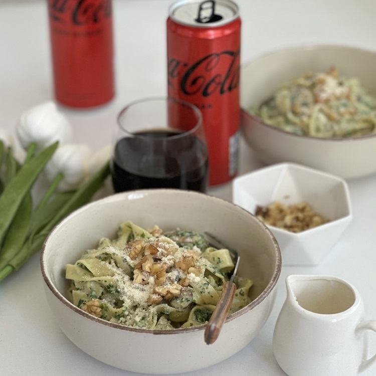 Pjatë makaronash me parmixhano dhe arra, gotë dhe kanaçe Coca-Cola.