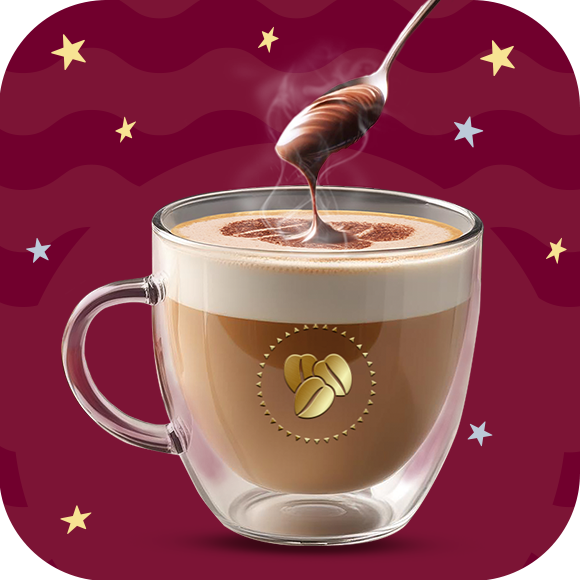 Una taza de cristal con café latte caliente y una cuchara por encima agregando crema de avellanas sobre un fondo en tonos guinda.