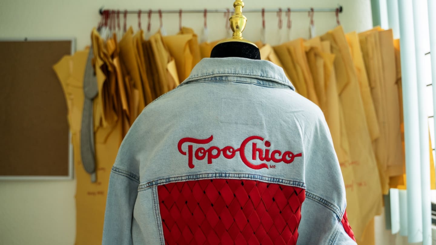Jean Jacket con bordado con el logo de Topo Chico y debajo un bordado todo rojo con rombos