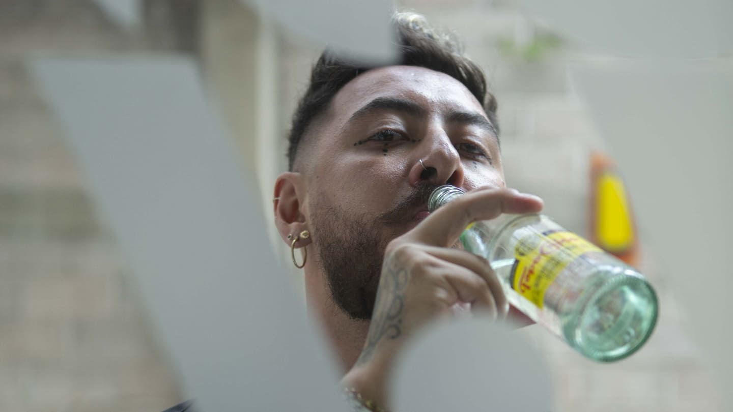 Imagen del artista Manuel Sosa con una botella de Topo-Chico