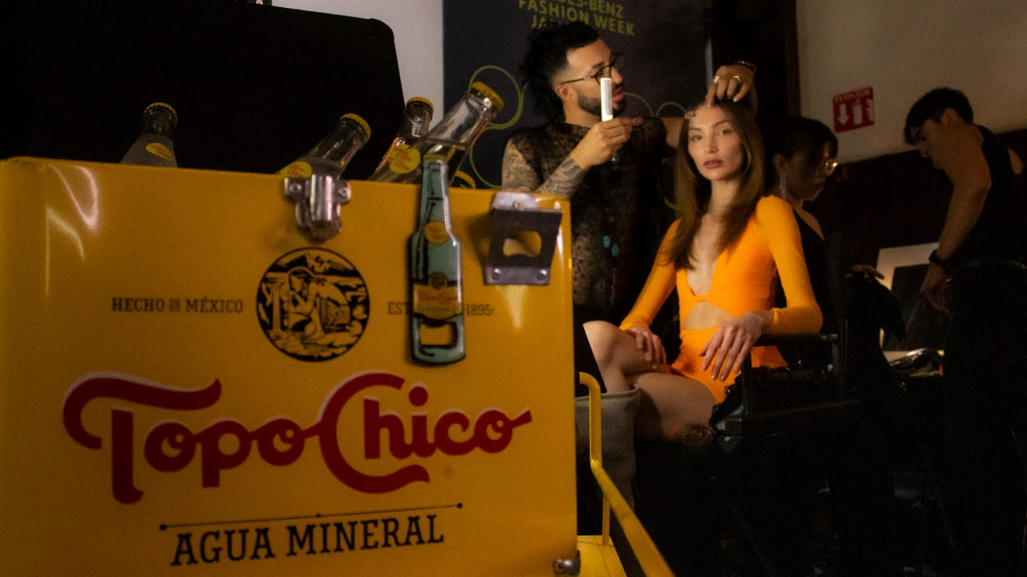 Refrigerador Topo Chico, con modelo con estilista de fondo.