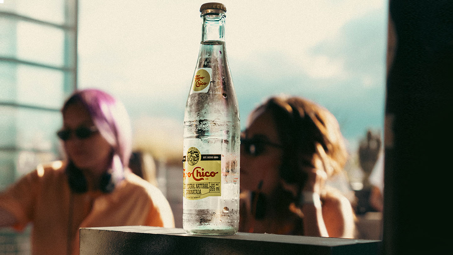 Botella de topo chico sobre cartel de Sunday Sunday