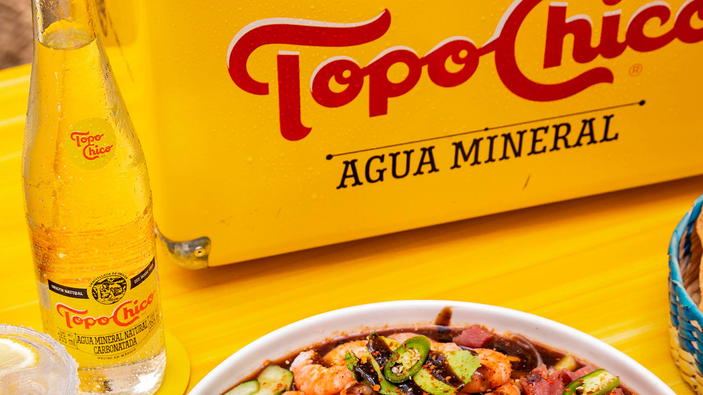 Presentacion de comida Gourmet con Topo Chico agua mineral.