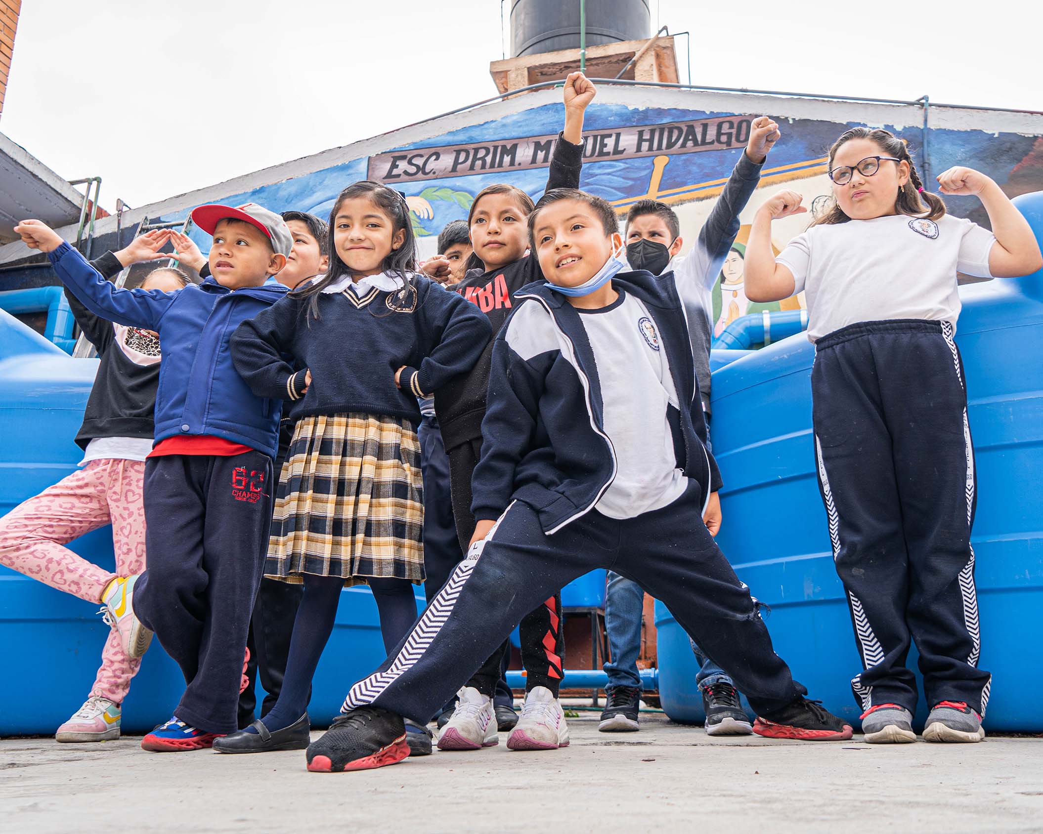 Imagen de un grupo de niños levantando las manos.