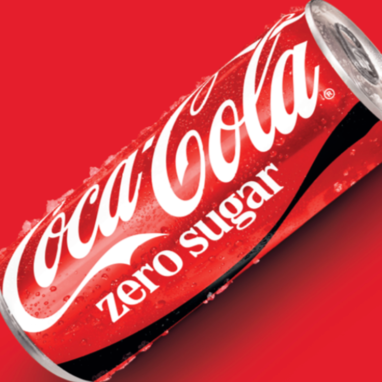 Une canette Coca‑Cola Zero Sugar bien fraîche, avec des gouttelettes de condensation, présentée en biais sur un fond rouge.