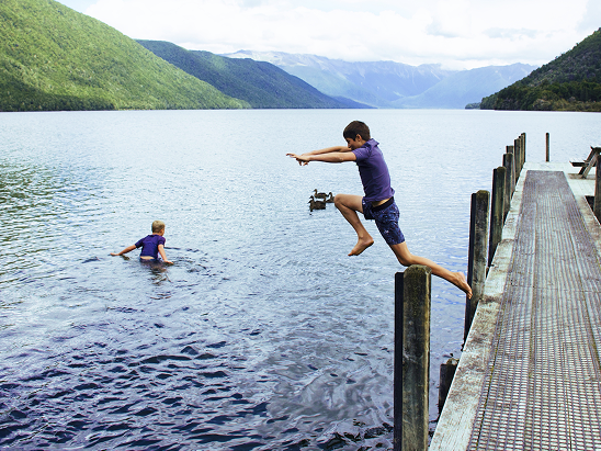 Children smiling while filling gallons with water