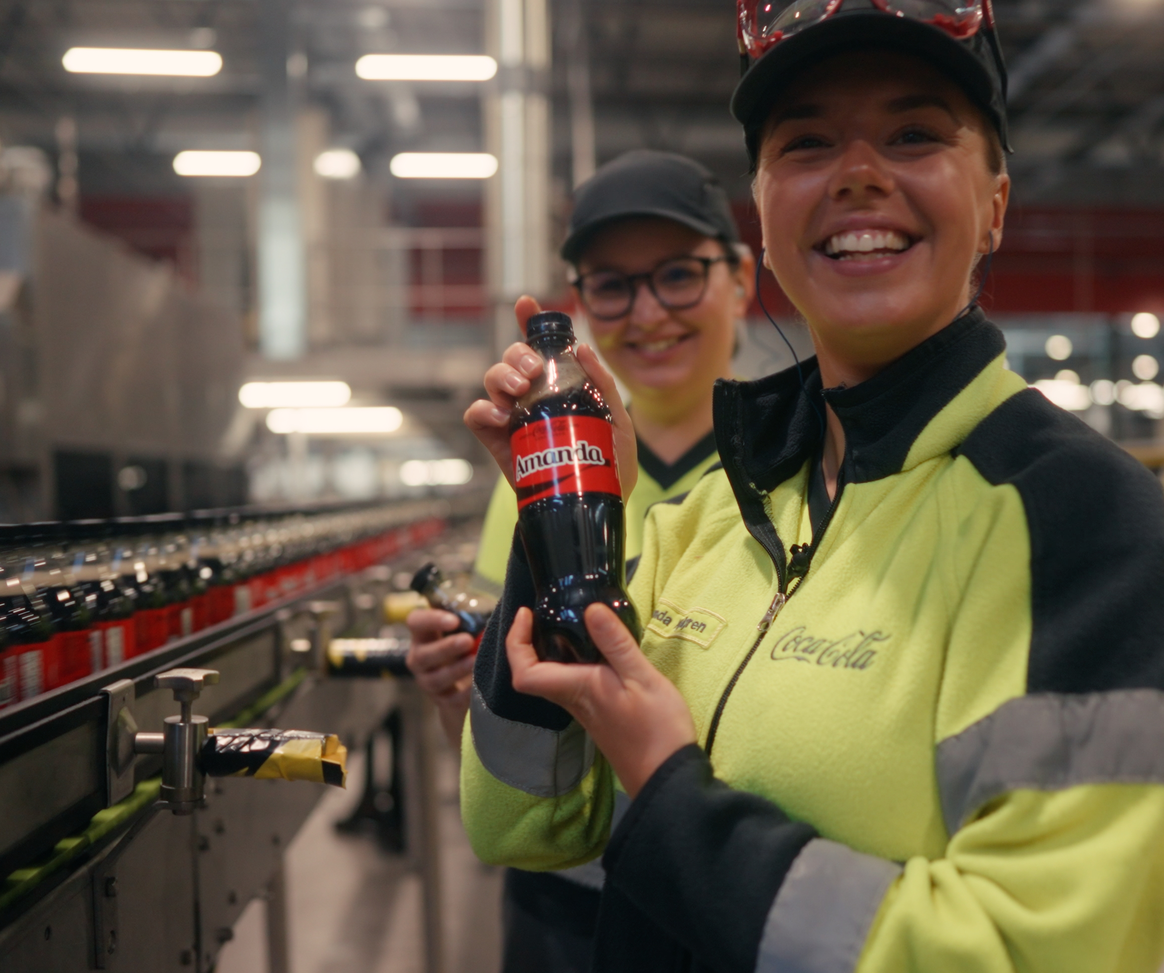Staplade Coca-Cola-burkar på röd bakgrund med text om att vinna produkter för ett helt år
