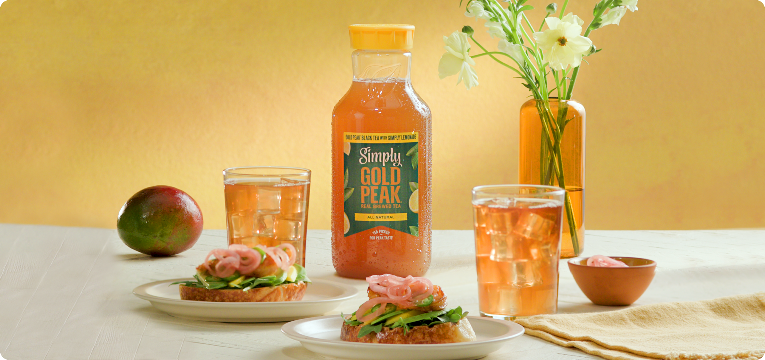 Gold peak tea drinks sitting on a table with food