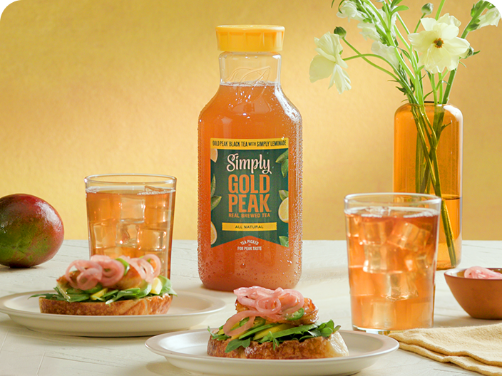 Gold peak tea drinks sitting on a table with food