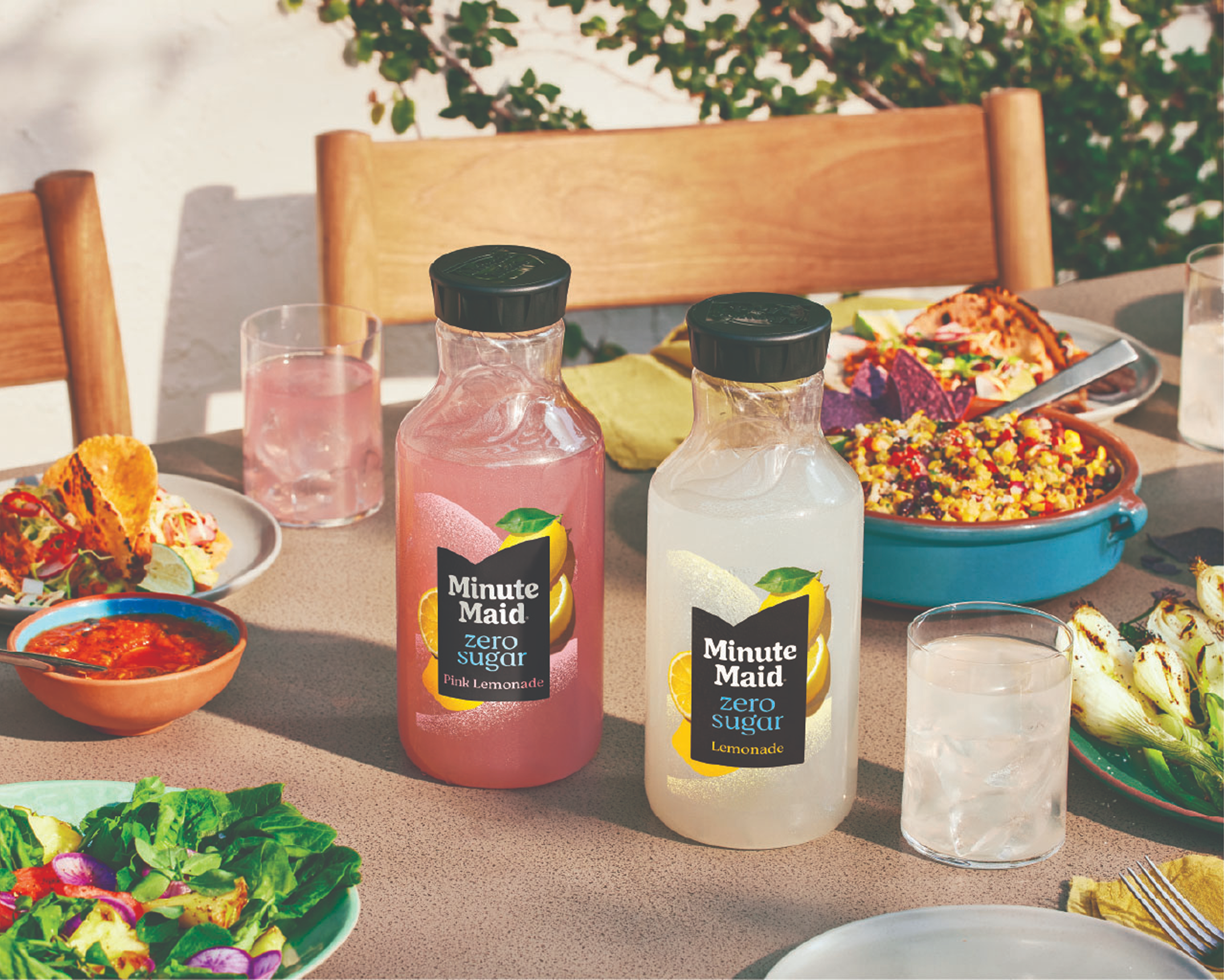 Two glasses toasting with a bottle of minute Maid Zero Sugar