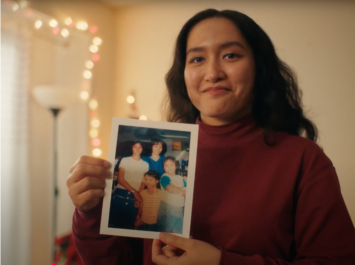 A woman holding a family photo up 
