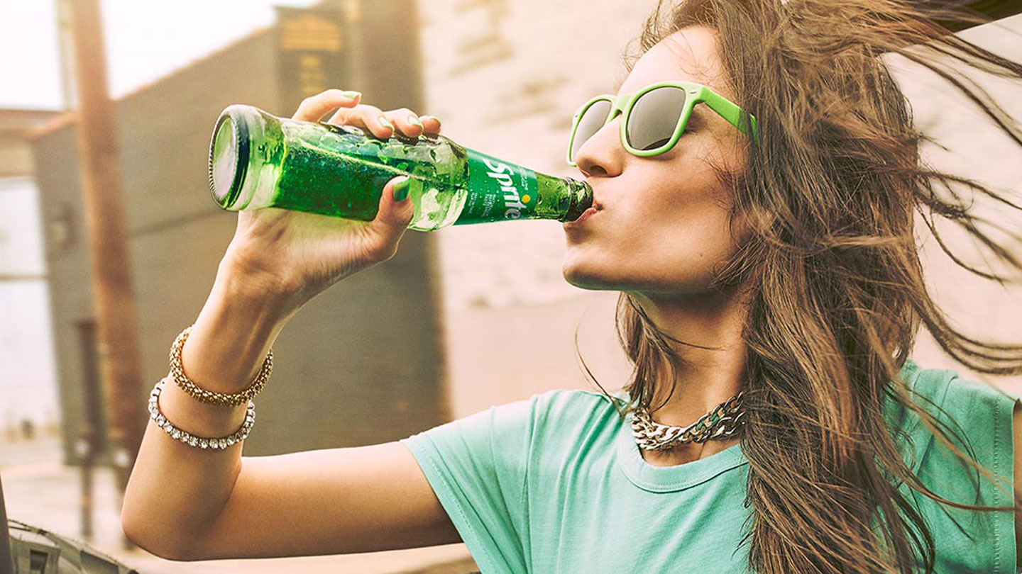 Person duke mbajtur një shishe Sprite në dorë.