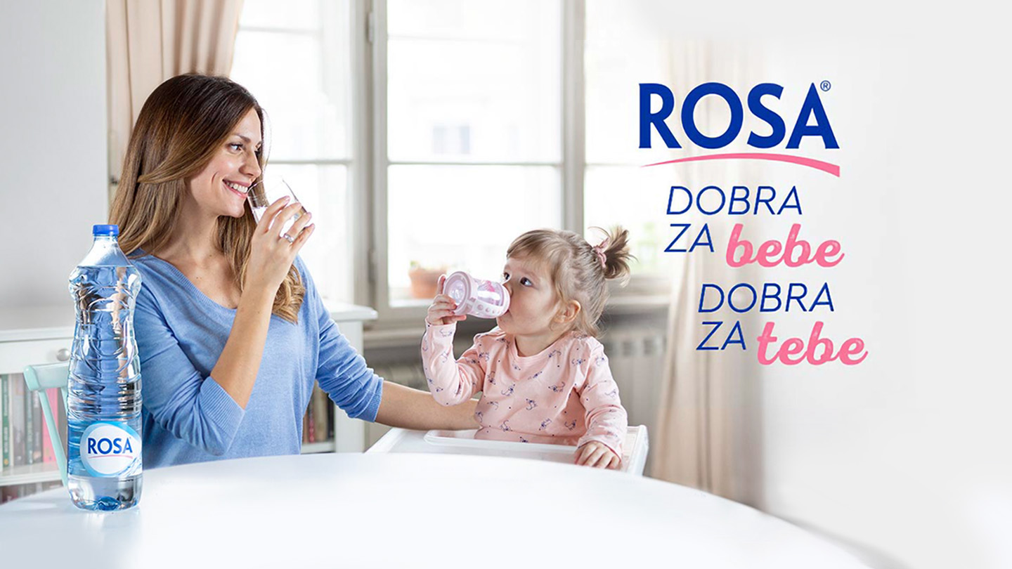 Žena i dete piju vodu Rosa za stolom